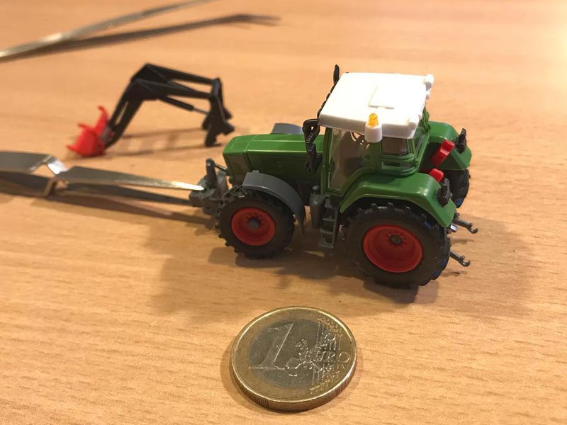 Traktor im Massstab 1 zu 87 zum Vergleich daneben eine 1-Euro-Münze
